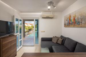 a living room with a couch and a tv at Villa 5 elements in Gostinjac