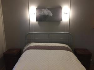 Un dormitorio con una cama con dos luces en la pared. en Modern waterfront chalet, en Geel