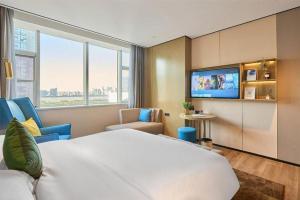 TV a/nebo společenská místnost v ubytování Echarm Plus Hotel Hangzhou Binjiang Xingguang Avenue