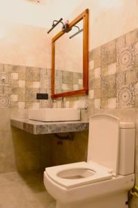 ein Badezimmer mit Toilette, Waschbecken und Spiegel in der Unterkunft Cinnamon Breeze Villa in Kandy