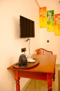 einen Holztisch mit einem Telefon darüber in der Unterkunft Cinnamon Breeze Villa in Kandy