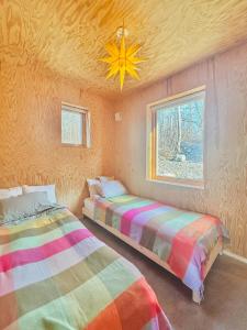 two beds in a room with a ceiling at Architect-Designed House Overlooking Valö Fjord in Hamburgsund
