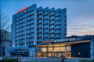 een hotelgebouw met een bord erop bij Hilton Garden Inn Chengde Mountain Resort in Niuquanzigou