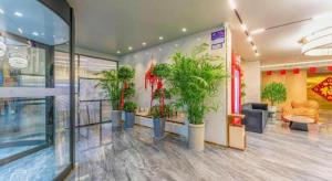 een lobby met een stel potplanten in een gebouw bij Borrman Hotel Jining High-tech Huangtun in Louzhuang