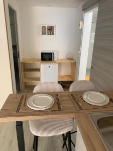 mesa de comedor con 2 sillas y microondas en L horizon, en Ravine des Cabris