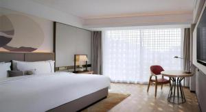 a bedroom with a large bed and a table and a window at Echeng Hotel Nanning the Mixc Convention in Nanning +46 photos