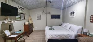 a bedroom with a white bed and a tv at Polly's Retreat in Coffin Bay