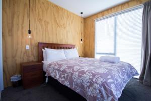 a bedroom with a bed with a purple blanket and a window at Nordic Escape - Lake Tekapo in Lake Tekapo
