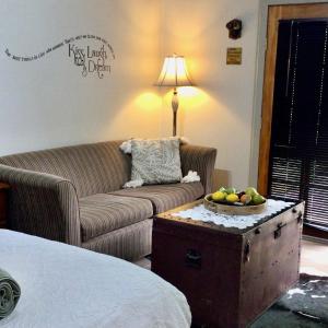 a living room with a couch and a table with a bowl of fruit at Polly's Retreat in Coffin Bay