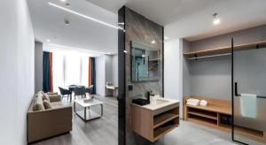 een badkamer met een bank en een wastafel in een kamer bij Borrman Hotel Jiangyin Zhouzhuang in Xiwujieqiao