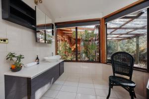 a bathroom with a sink and a chair at Bimbi Forest Eco Lodge - Denmark in Denmark
