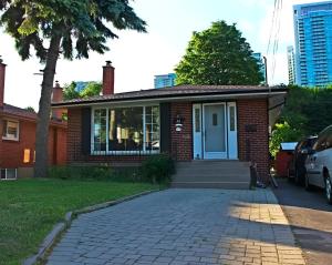 a small brick house with a blue door at Cozy Private 2 bedroom apartment, free Wifi, free parking in heart of Toronto, surrounded by nature in Toronto