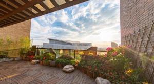 a patio with flowers and plants on a building at Tomeet Hotel in Meizhou