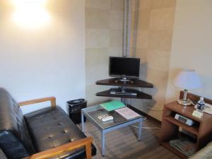 a living room with a couch and a tv and a table at Hotel Cerezo in Tokyo