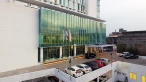 a view of a building with cars parked in a parking lot at Odua Weston Jambi in Jambi