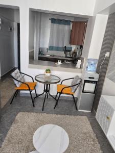 uma sala de estar com mesa e cadeiras e uma cozinha em Hami Ventures em Kisumu