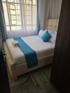 uma cama em um quarto com janela em Hami Ventures em Kisumu