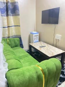 a living room with two green chairs and a table at Danfo in Mto Panga