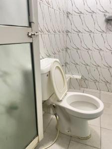 a white toilet in a bathroom with a wall at Danfo in Mto Panga +2 photos