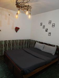 a bed in a bedroom with a chandelier at kMT ooty villa mangal niketen in Ooty