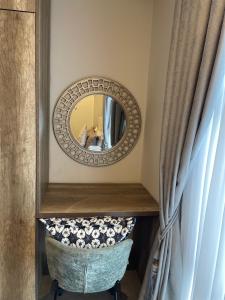 a mirror on a wall next to a curtain at Cantonments One Bedroom Deluxe in Accra