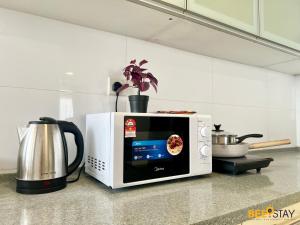 um micro-ondas sentado num balcão numa cozinha em D'Aman Residences in Puchong for 6 Pax em Puchong