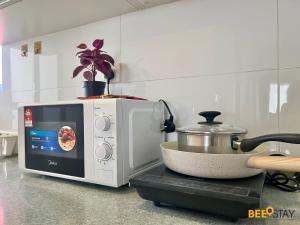 um forno de micro-ondas sobre um balcão de cozinha em D'Aman Residences in Puchong for 6 Pax em Puchong