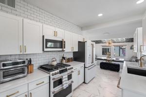 Una cocina con gabinetes blancos y un horno de estufa. en Casa Lumina, en Phoenix