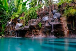 - une cascade dans la piscine d'un complexe avec de l'eau bleue dans l'établissement Bumbung Sari Villa, à Ubud