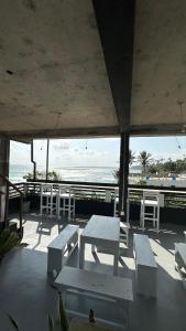 a patio with white tables and chairs and the ocean at The Reef Weligama in Weligama