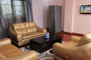 a living room with leather chairs and a coffee table at Yinm Guest house in Addis Ababa