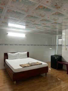 芹苴Tây Đô Hostel的一间卧室，里面有一张床，天花板上装饰着鲜花。