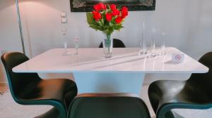 a white table with a vase of red flowers on it at Andromache's Cozy Villa close to Meteora-Trikala in Tríkala
