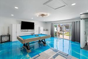 een pooltafel in een woonkamer met blauwe vloer bij Casa Lumina in Phoenix