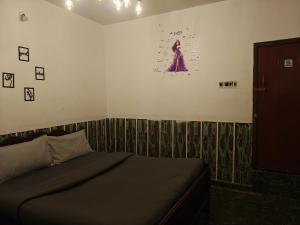 a bedroom with a bed and a picture on the wall at kMT ooty villa mangal niketen in Ooty