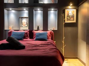 une chambre avec un grand lit avec des oreillers bleus dans l'établissement La cinemaRoom d'Auterive - Son Immersif Dolby et Atmos - Netflix, à Auterive