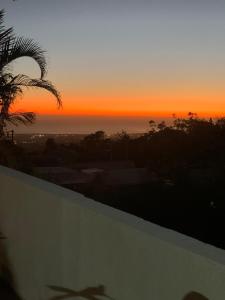 una puesta de sol sobre el océano con una palmera en L horizon, en Ravine des Cabris