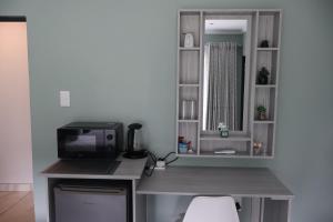 a kitchen with a desk with a microwave and a computer at GuestHouseVine&Stone in Clarens +52 photos