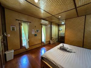 a bedroom with a bed with a stuffed animal on it at FourTwoEight Pai Resort in Kampong Huaibū