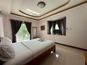 a bedroom with a large bed and a window at ชอว์ งาทอง รีสอร์ต Chor Ngar Thong Erawan Kanchanaburi in Kanchanaburi