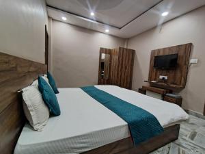 a bedroom with a large bed and a television at Hotel Grand Stay in Bhopal