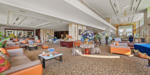 a large lobby with couches and tables and flowers at Sandals Stay Hotel in Da Nang