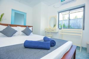 a bedroom with a bed with blue pillows on it at Villa Amor by the Beach in Ambalangoda