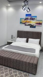 een slaapkamer met een groot bed met een bruin hoofdeinde bij Relax Home in Barka