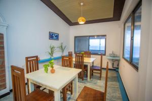 a dining room with tables and chairs and the ocean at Villa Amor by the Beach in Ambalangoda