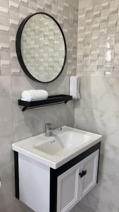 een badkamer met een wastafel en een spiegel bij Relax Home in Barka