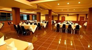 a banquet hall with white tables and black chairs at Phuthong Place in Phayao