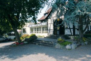 a white building with trees and flowers in front of it at Romantik Hotel Johanniter-Kreuz in Überlingen