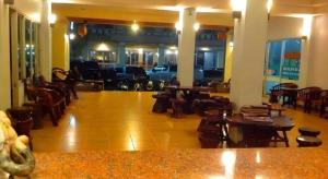 een lobby met tafels en stoelen en een parkeerplaats met auto's bij Chanthanee Hotel in Ban Chamun (2)