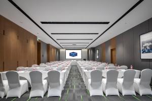 een vergaderzaal met witte tafels en witte stoelen bij Hilton Garden Inn Chengde Mountain Resort in Niuquanzigou
